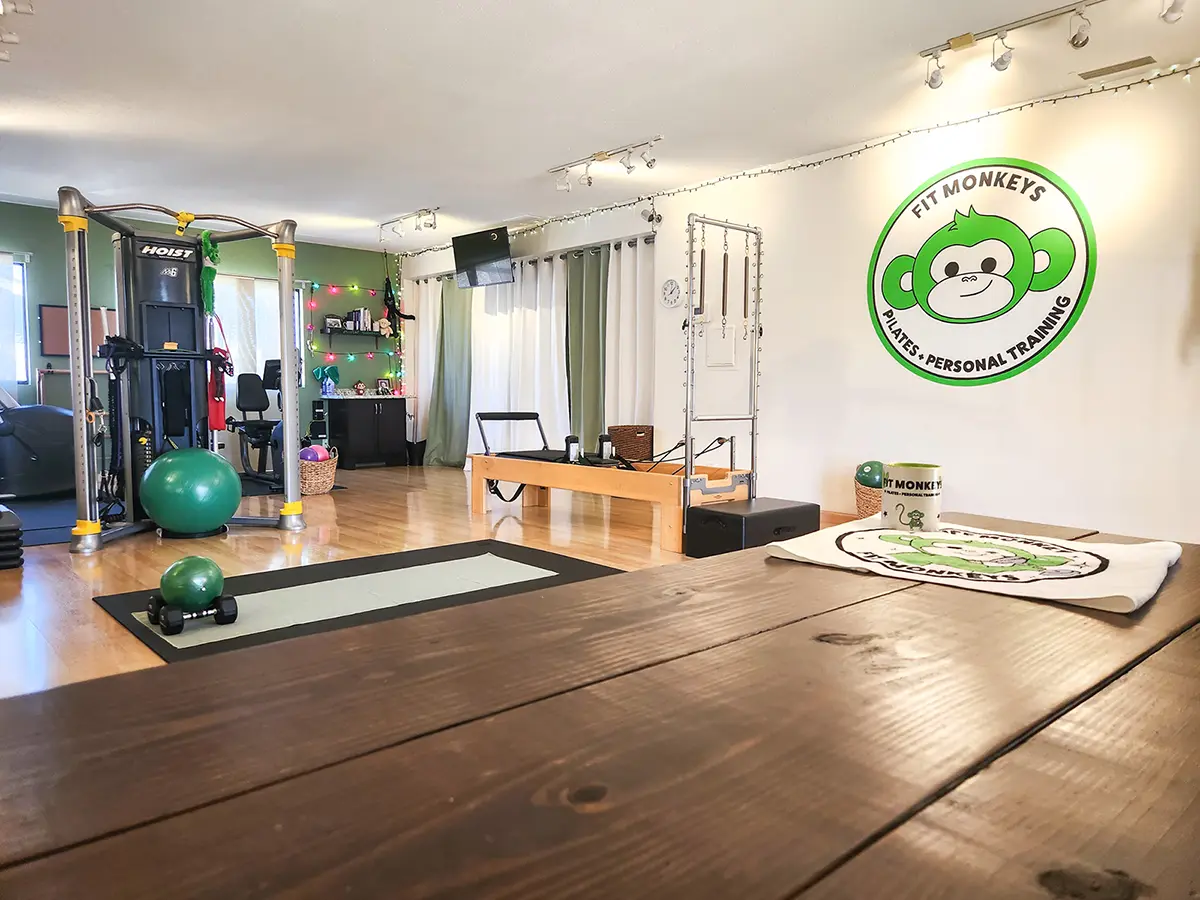 Fit Monkeys private personal training studio in Carlsbad with a Pilates reformer, cable machine, and Fit Monkeys mural.